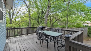 A wooden deck with a table and chairs, surrounded by a wooden fence and trees. - Relax And Unwind In The Heart Of Fayetteville 2 Bedroom Home (Fayetteville)