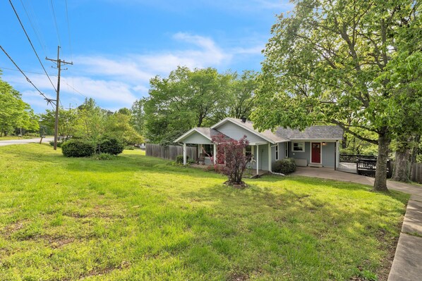 A single-story house with a front porch, a small yard, and a tree. - Relax And Unwind In The Heart Of Fayetteville 2 Bedroom Home (Fayetteville)