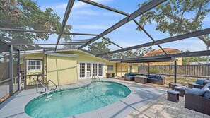 Una piscina scoperta coperta con una zona solarium, comprensiva di posti a sedere e un ingresso coperto.