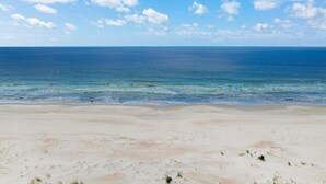 Une plage avec un ciel dégagé et une mer calme.