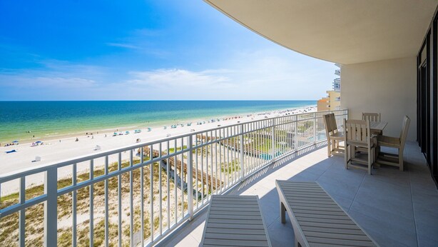 Ein Balkon mit Blick auf Strand und Meer.