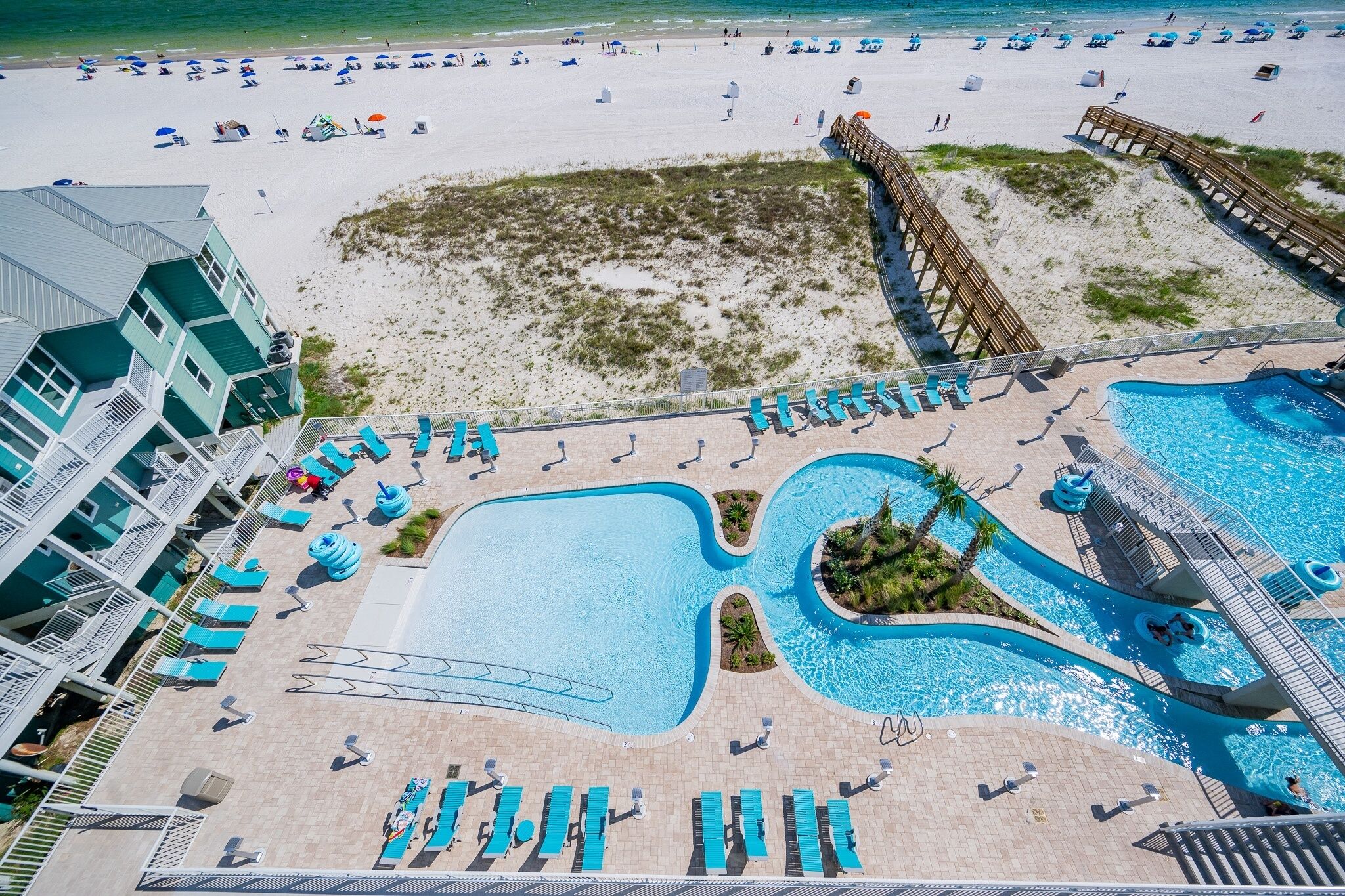 A resort with a large pool area, beach access, and a building with balconies.