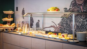 Ein reichhaltiges Buffet mit verschiedenen Speisen und einer Wand mit einer Bärenillustration.
