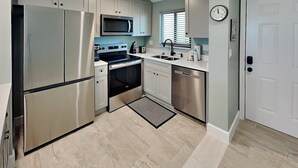 A modern kitchen with stainless steel appliances, a microwave, a stove, and a dishwasher.