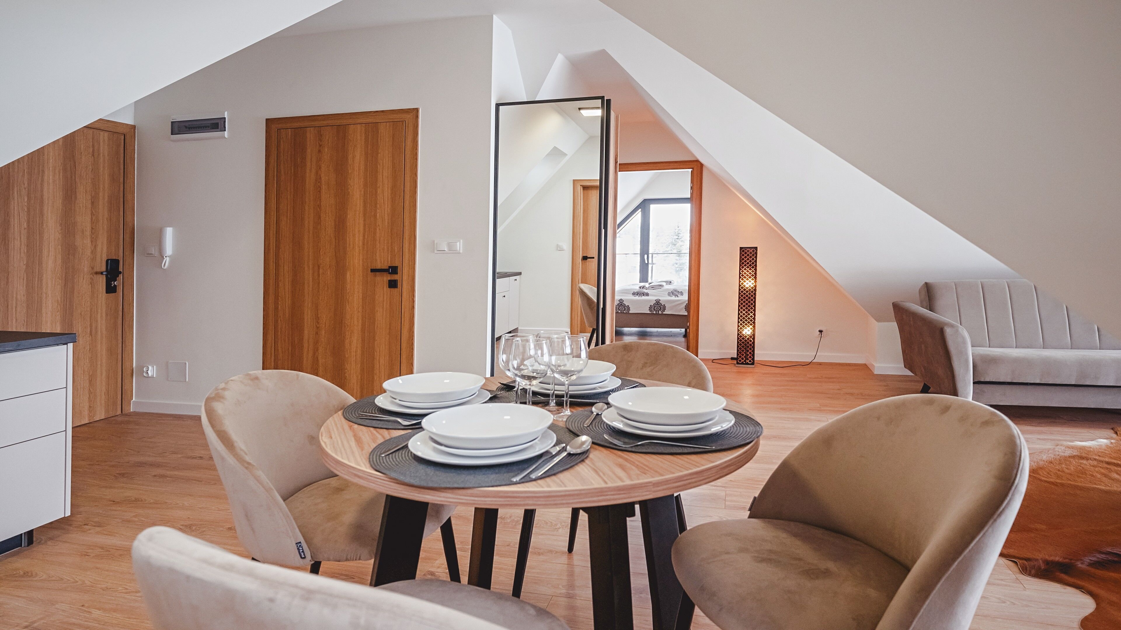 Un loft moderno con comedor, sofá y una escalera que sube a un nivel superior.