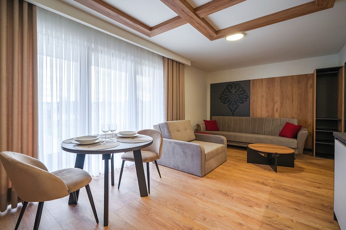 A modern living room with a dining area, a sofa, and a coffee table.
