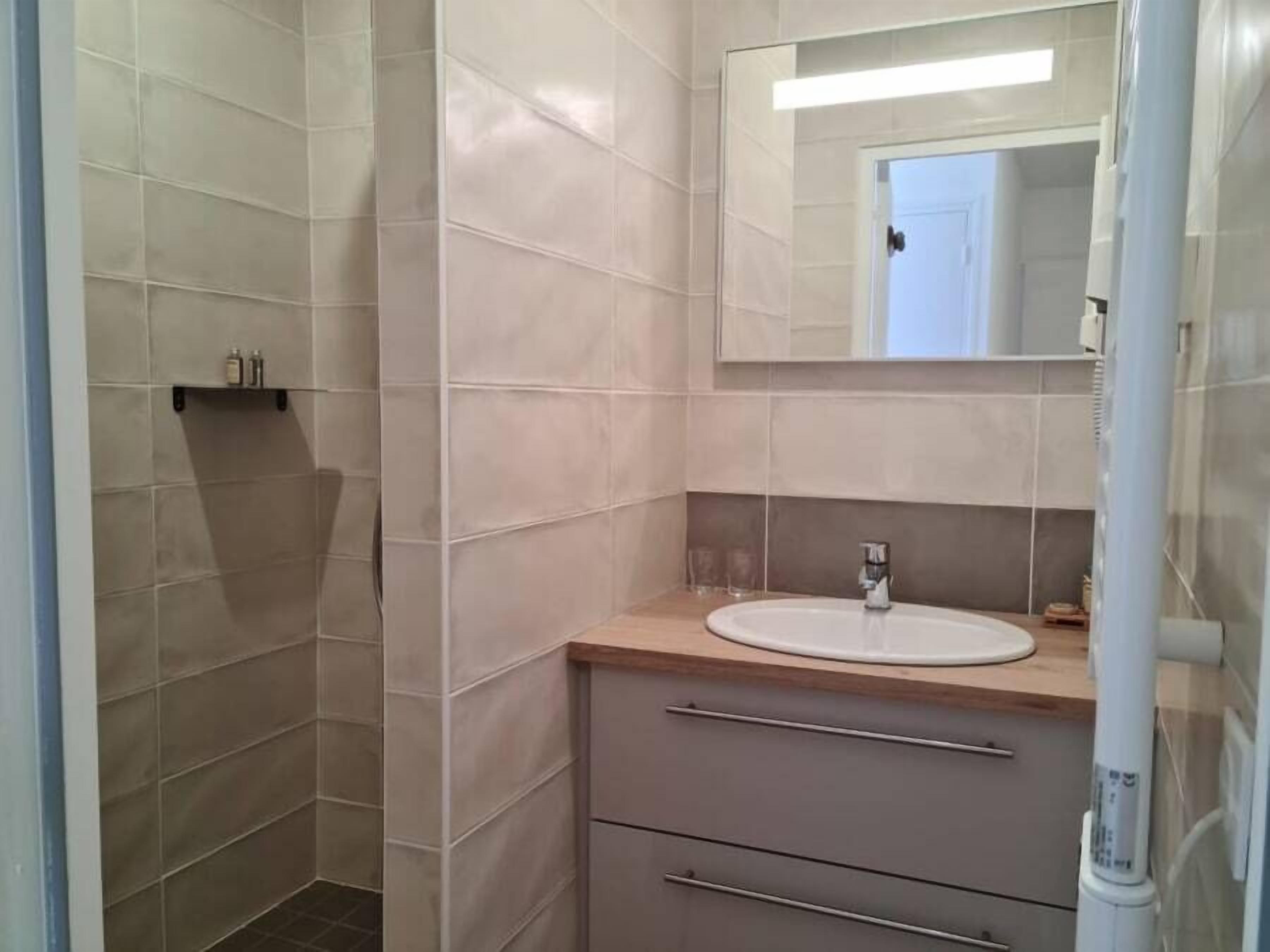 A bathroom with a white sink, a mirror, and a towel rack.