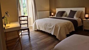 Een slaapkamer met een bed, nachtkastjes, een stoel en een bureau.