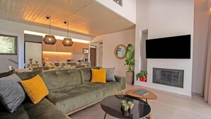 Ein modernes Wohnzimmer mit einem grünen Sofa, einem Couchtisch und einem Kamin.