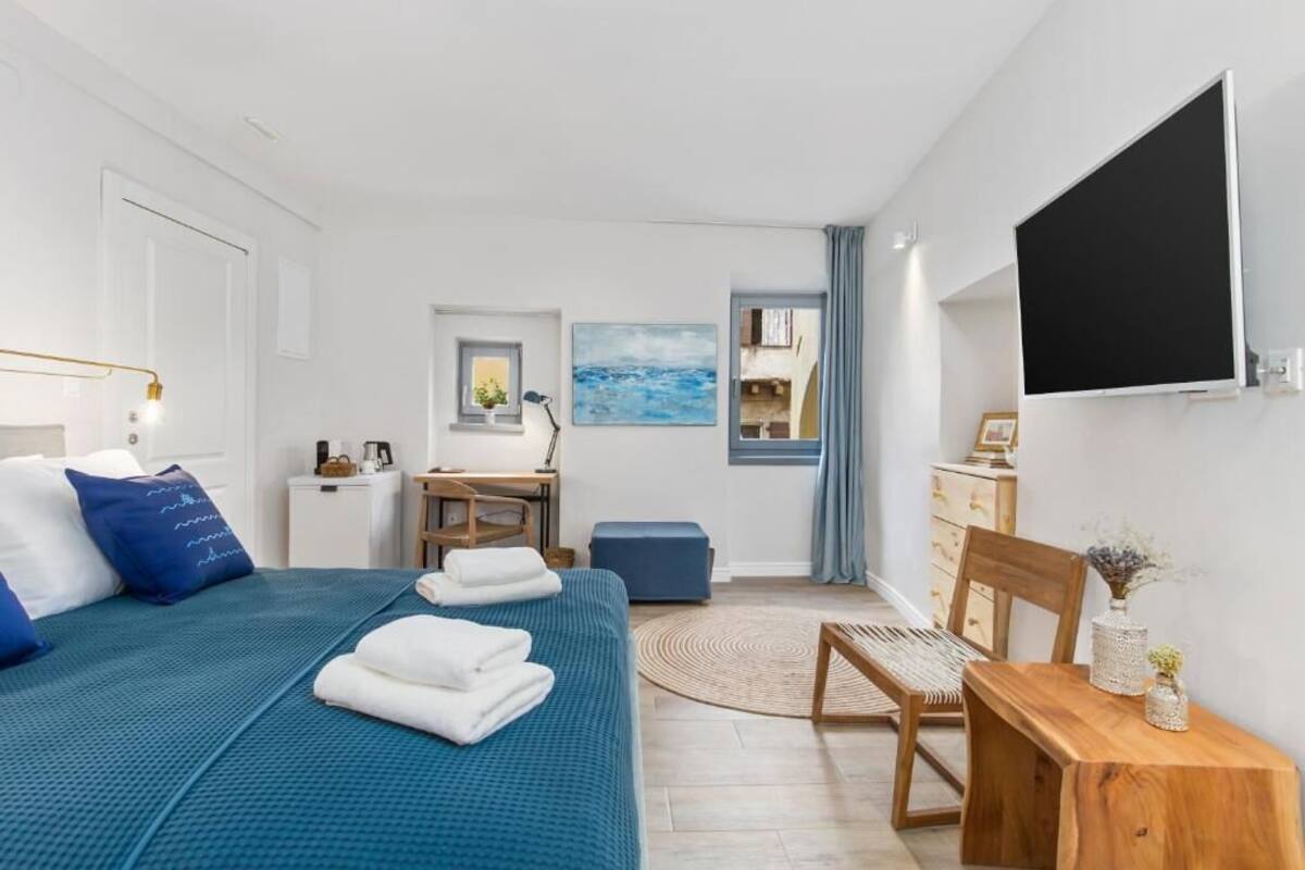 Un dormitorio moderno con una cama grande, un escritorio, una silla y un televisor.