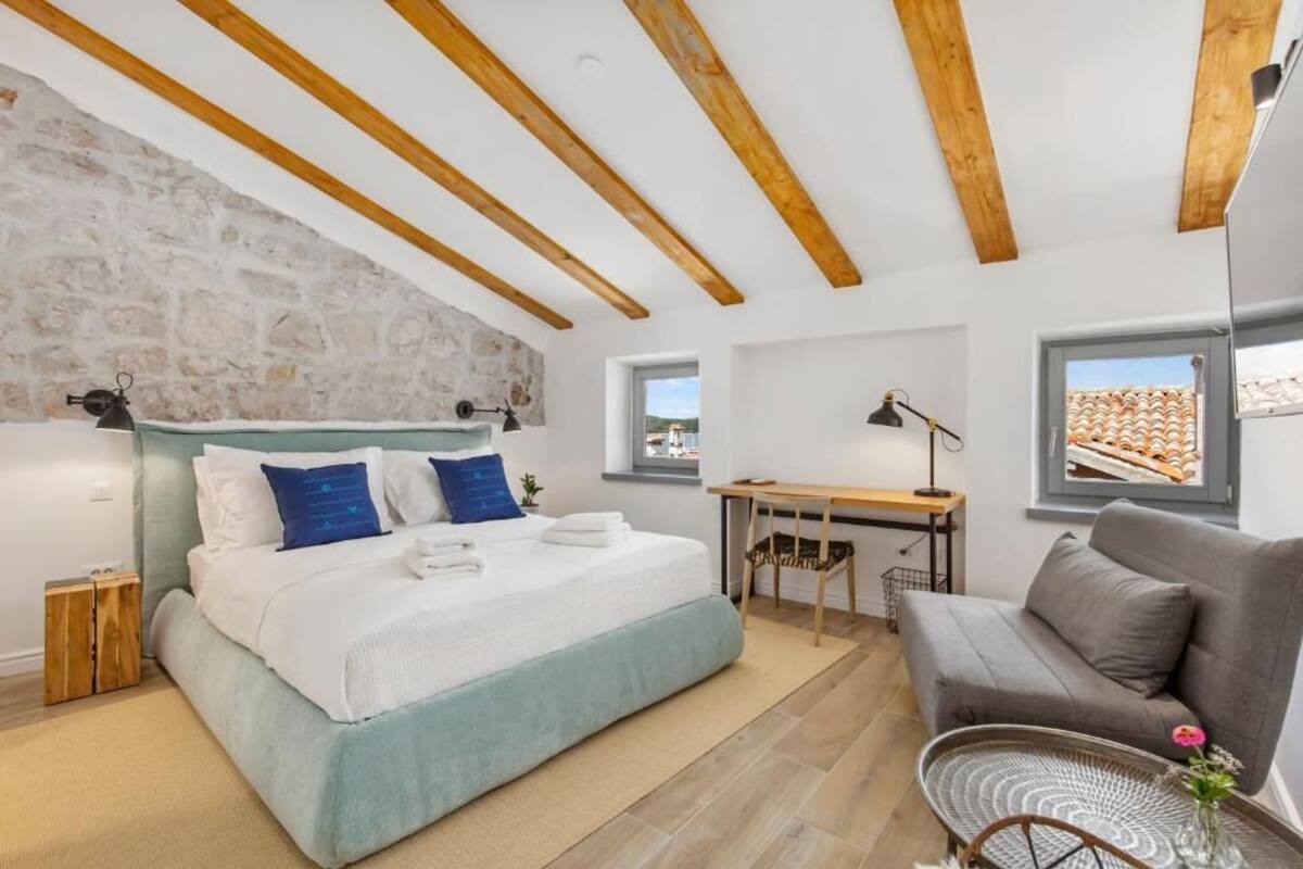 Un dormitorio con cama, escritorio y sofá.