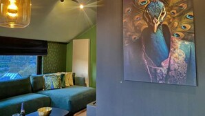 A modern living room with a green sofa, a coffee table, and a painting of a peacock on the wall. - House in Durbuy Near Town Center (Durbuy)