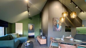 A modern living room with a sofa, coffee table, and dining area with chairs and a table. - House in Durbuy Near Town Center (Durbuy)
