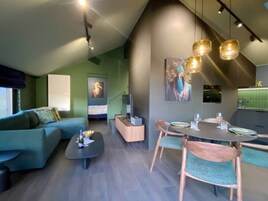 Una sala moderna con sofá, mesa de centro y comedor con sillas y una mesa.