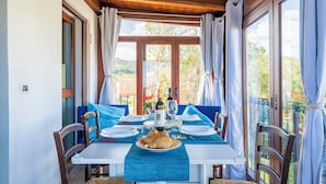 A dining table set for two with a view of the countryside.