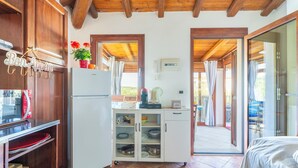 A compact kitchen with a refrigerator, microwave, and a cabinet with dishes.