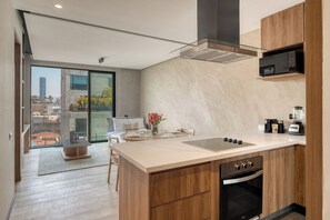 A modern kitchen with a large island, built-in oven, and a microwave.