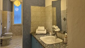 Une salle de bain équipée d’un lavabo, d’un miroir et d’un porte-serviettes.