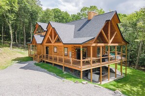 A log cabin with a deck and a covered outdoor area.