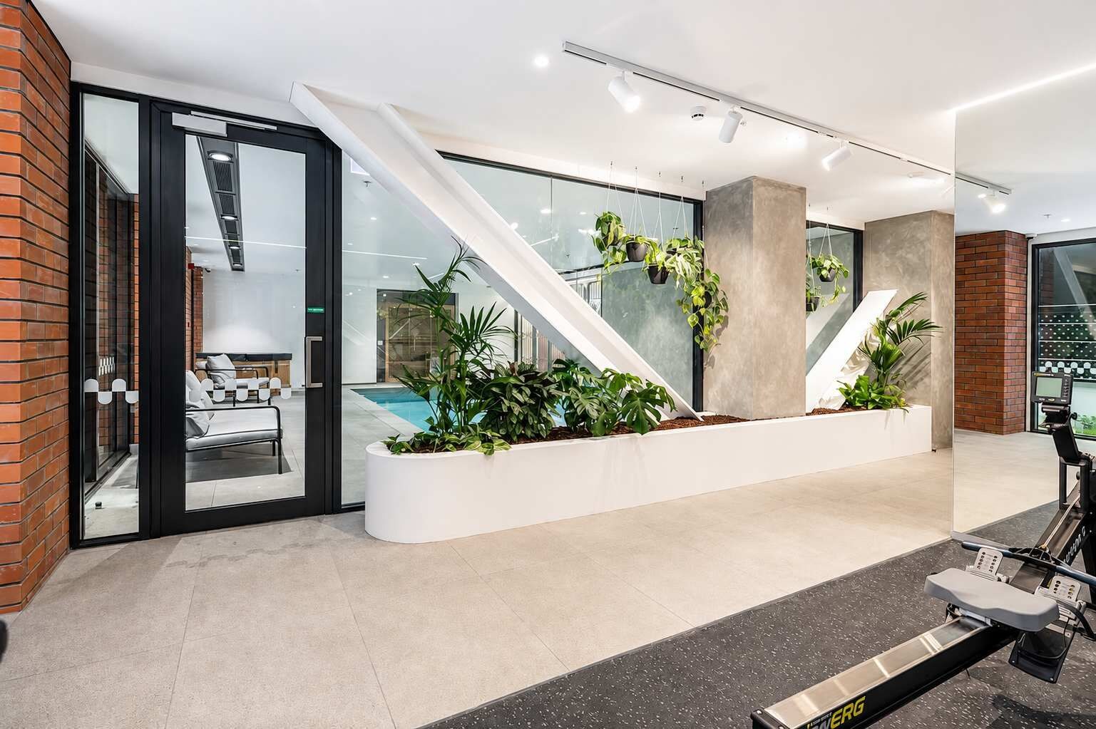Un espace intérieur moderne comprenant un coin salon, un escalier et un vélo d’appartement.