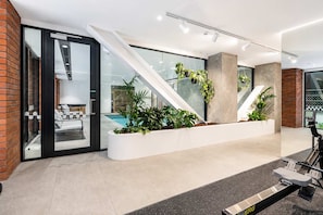 A modern indoor space with a seating area, a staircase, and a stationary bike.