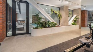 Een modern interieur met een trap, kamerplanten en fitnessapparatuur.