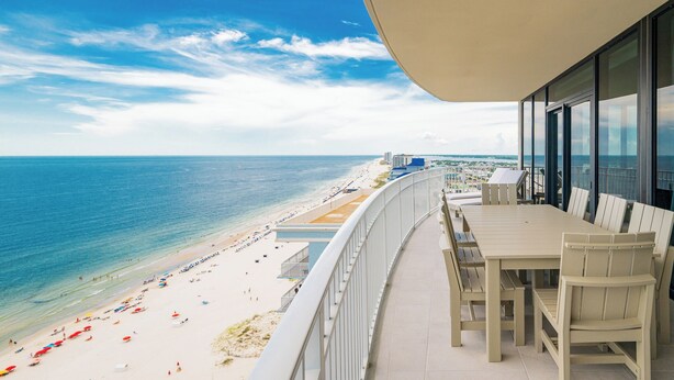 A balcony with a view of a beach and ocean.