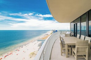 En balkon med udsigt over strand og hav.