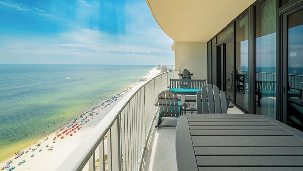 A balcony with a view of a beach and ocean.