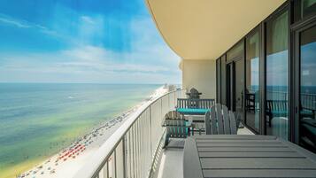 A balcony with a view of a beach and ocean.