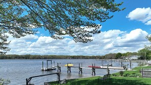 A lakeside park with a wooden dock, a swing set, and a picnic table. - Gorgeous Waterfront Home in the Heart of North Kingstown (North Kingstown)