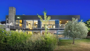 A modern two-story building with a balcony and a staircase leading to the upper floor.