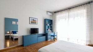 A bedroom with a bed, a desk with a chair, a TV, and a bookshelf. - notaMi - Feels Like Home (Milan)