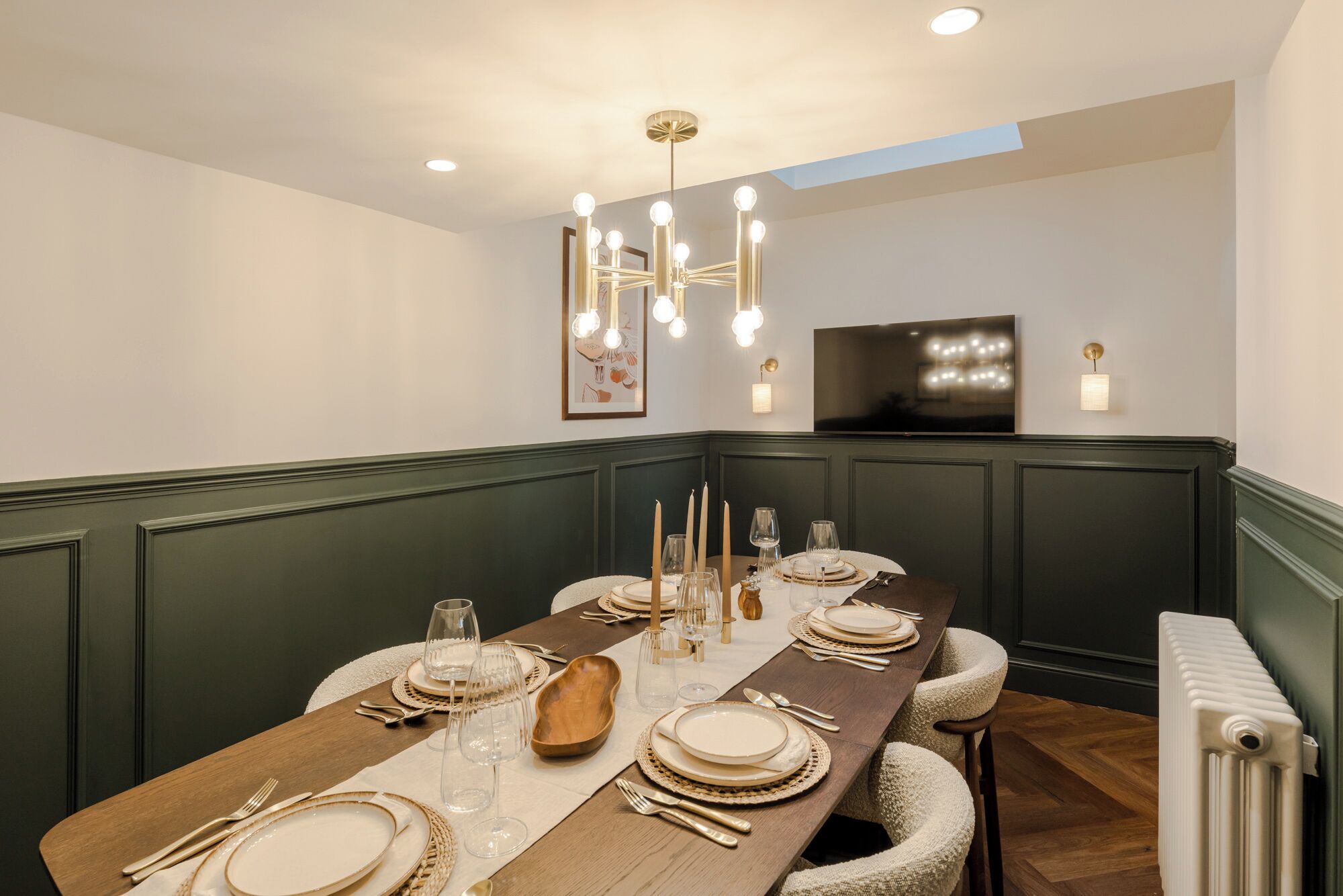 A dining area with a long wooden table set for a meal, featuring clear glassware, plates, and cutlery.