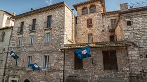 Ein historisches Steinhaus mit zahlreichen Fenstern und Balkonen, verziert mit Flaggen und traditionellen architektonischen Details.