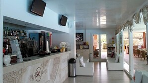 Eine moderne Hotelhalle mit Barbereich, Sitzgelegenheiten und einem Fernseher.
