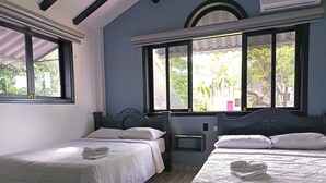 Ein Zimmer mit zwei Betten, einem Fenster mit Blick auf Grünflächen und einem Dachfenster.