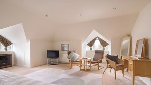 Une chambre spacieuse avec un grand lit, un bureau, une chaise et un téléviseur.