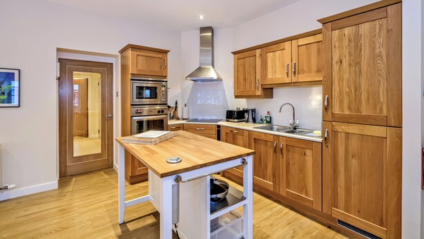 Une cuisine moderne avec des meubles en bois, des appareils en acier inoxydable et un îlot central.