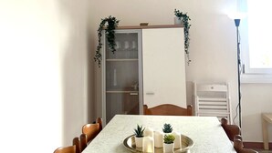 Un comedor con una mesa larga, sillas y una bandeja con velas y pequeñas plantas.