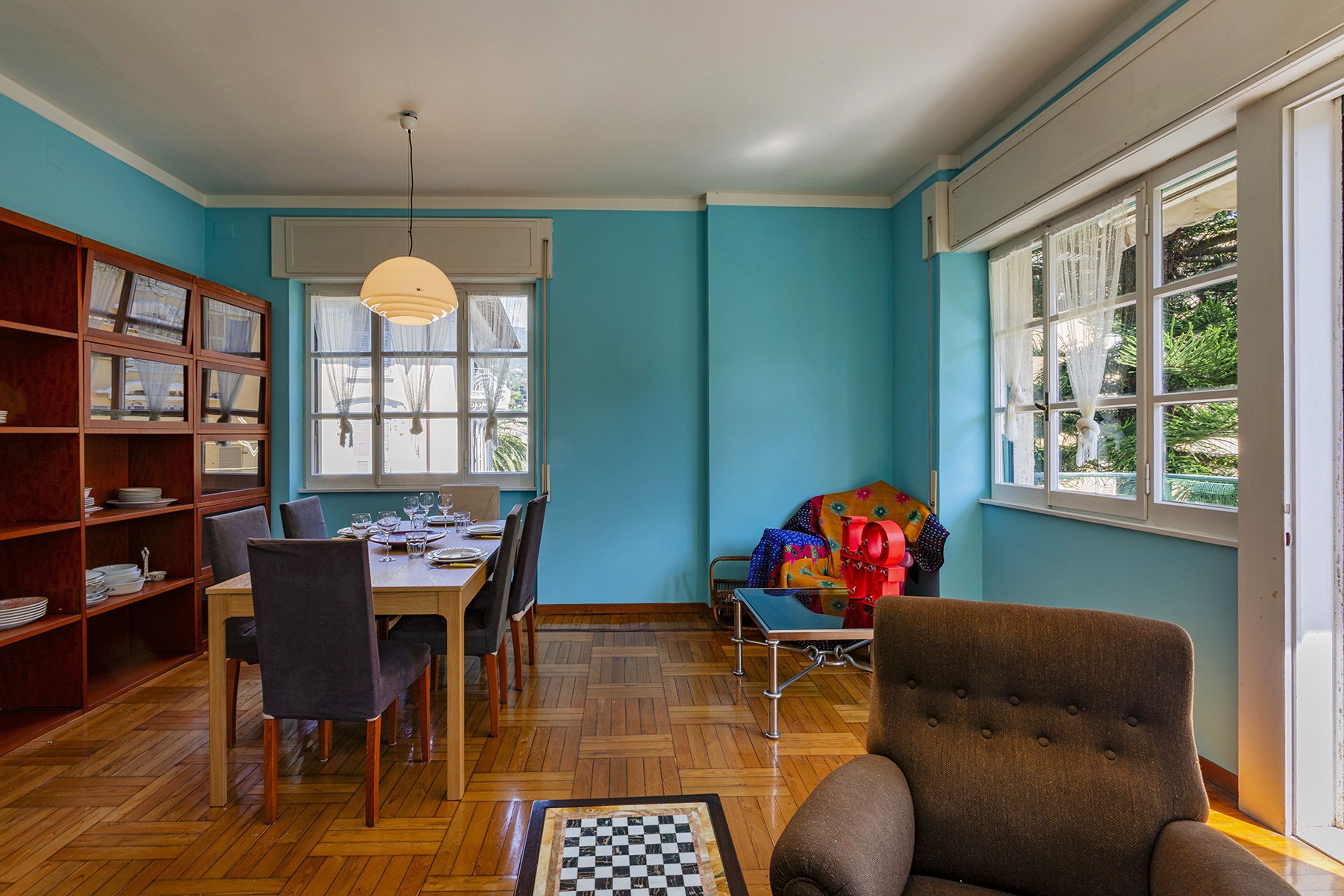 A dining area with a wooden table, chairs, and a bookshelf.