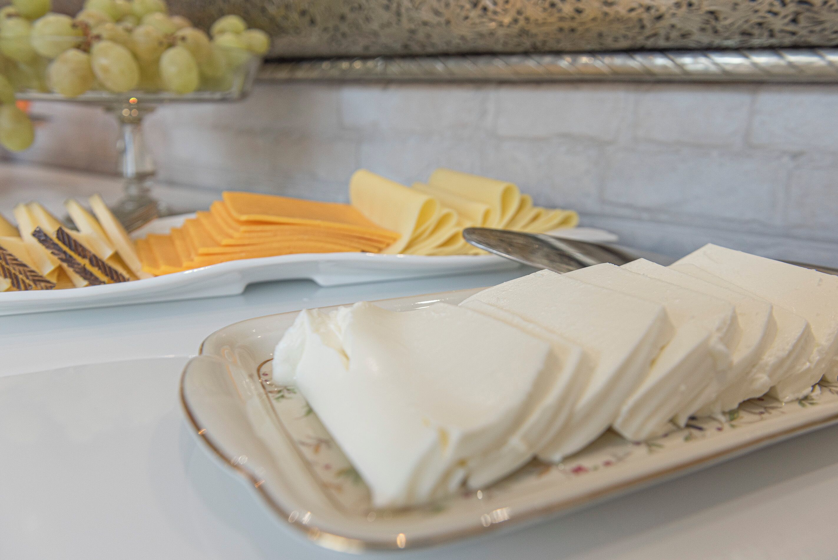 A buffet table with various food items including cheese, crackers, and a plate of cream cheese.