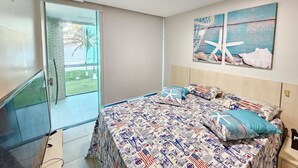 A bedroom with a bed, a TV, a window with a view, and a painting on the wall.
