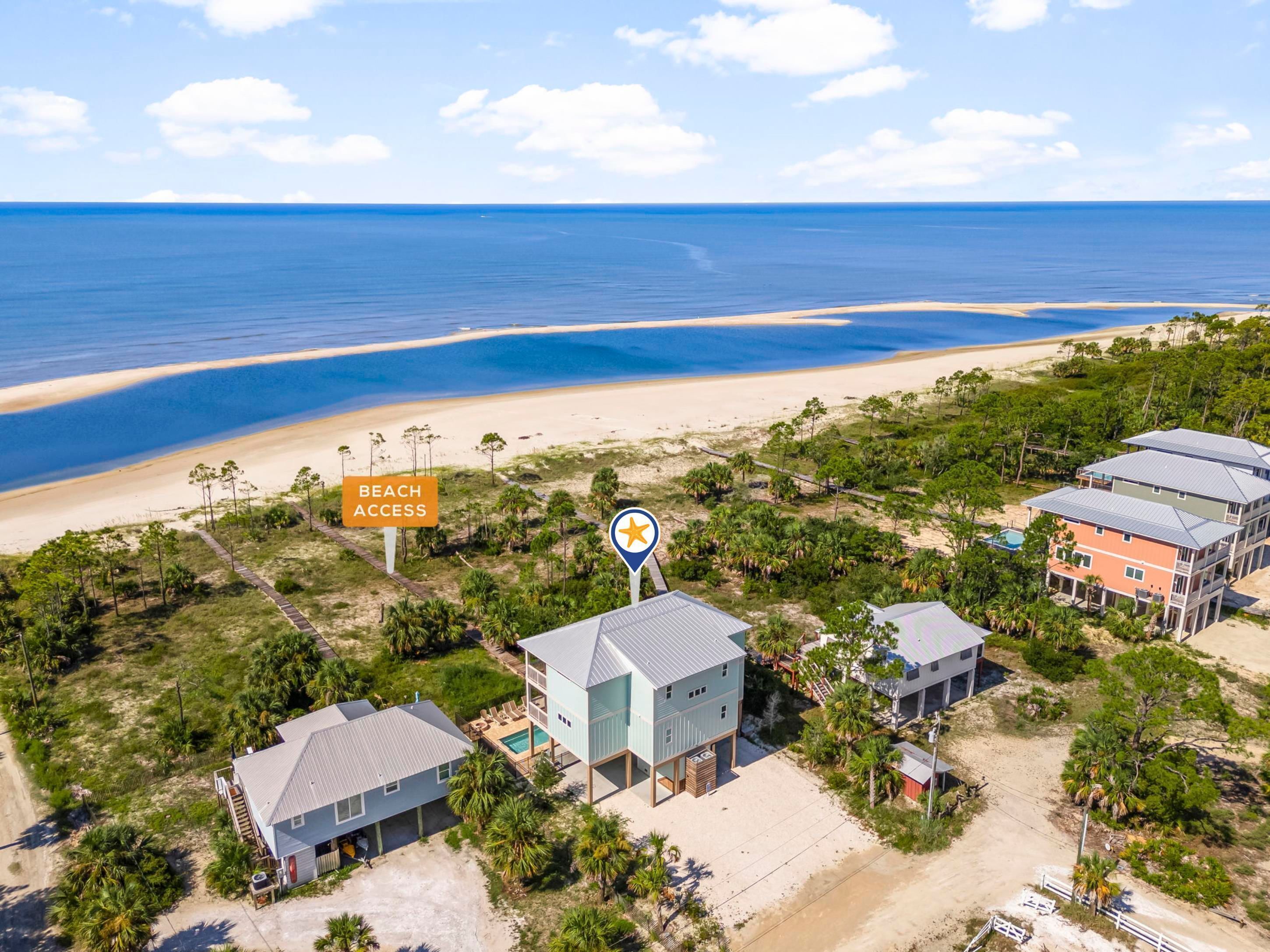 A coastal property with beach access, multiple buildings, and a clear view of the ocean.