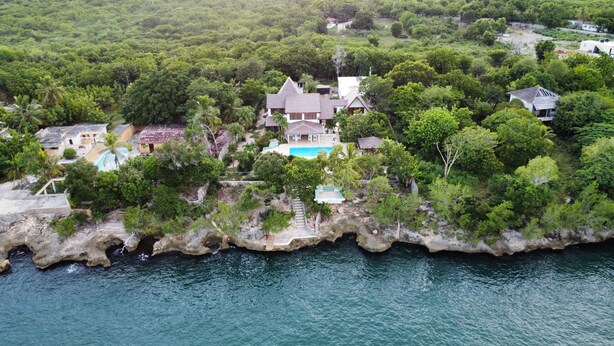 An aerial view of a coastal property with multiple houses, a swimming pool, and lush greenery. - RioMar Cumayasa. Nature, peace and quiet. Time out between river, sea and palm trees (La Romana)