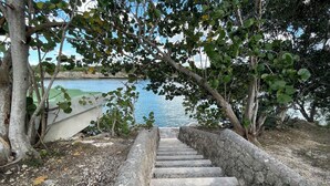 A stone staircase leading to a dock by a body of water, surrounded by trees. - RioMar Cumayasa. Nature, peace and quiet. Time out between river, sea and palm trees (La Romana)