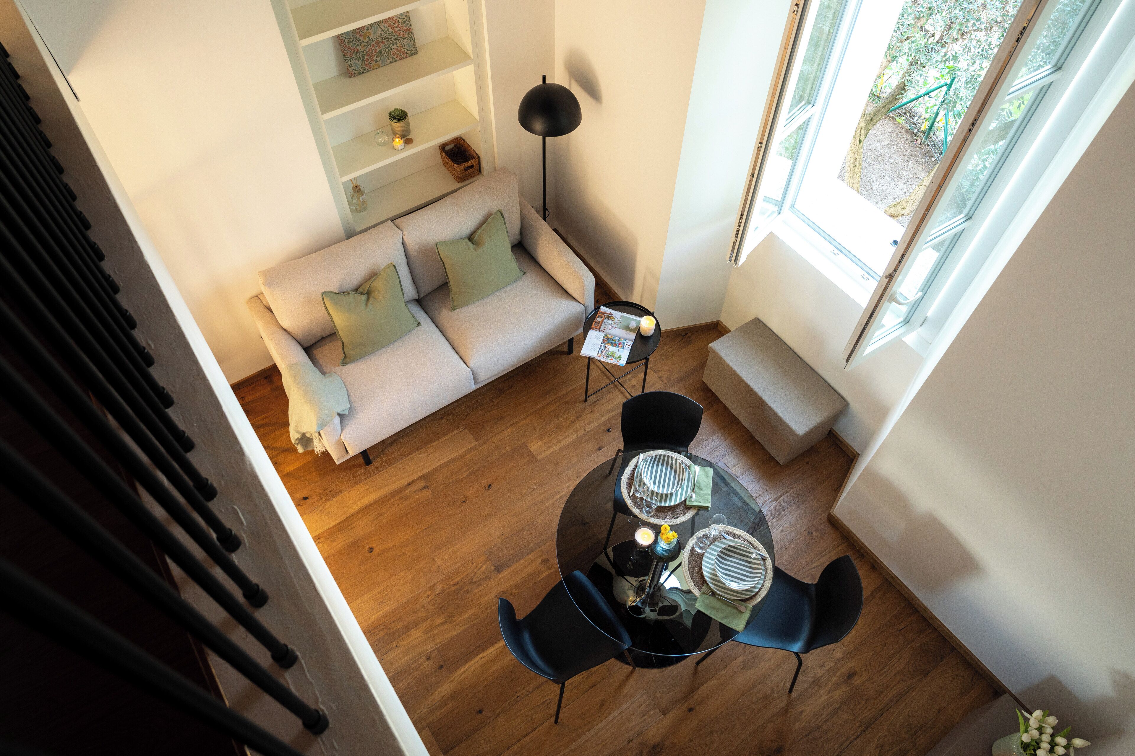 A modern living room with a sofa, a glass dining table, and a floor lamp.