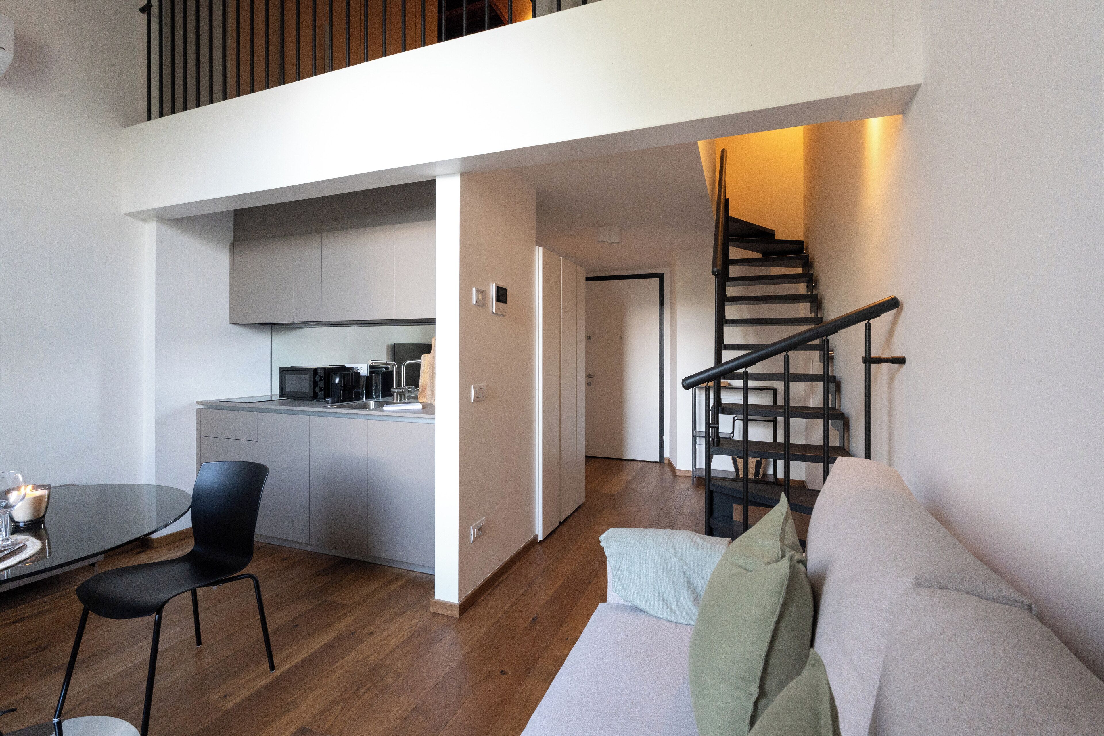 Un apartamento moderno con cocina, comedor y una escalera.
