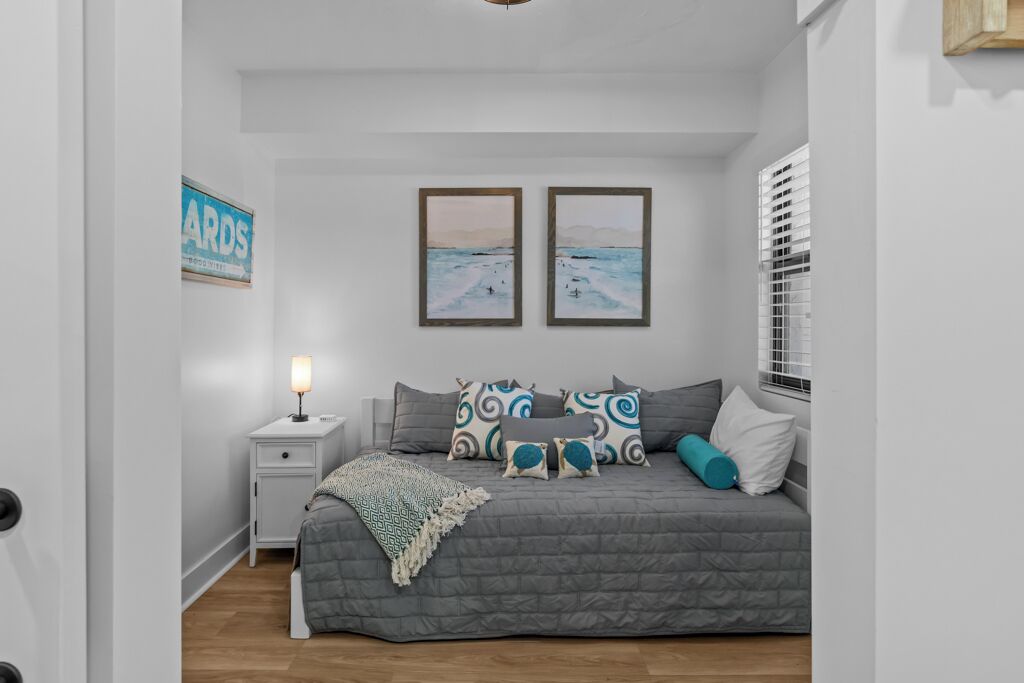 A bedroom with a bed, nightstand, and wall art.