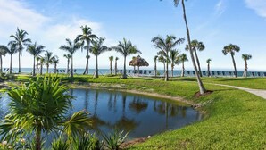 A tropical resort with a pool, palm trees, and a view of the ocean. - Modern Gulf-Front Condo in Sanibel – Newly Renovated & Ready for Your Escape (Sanibel)